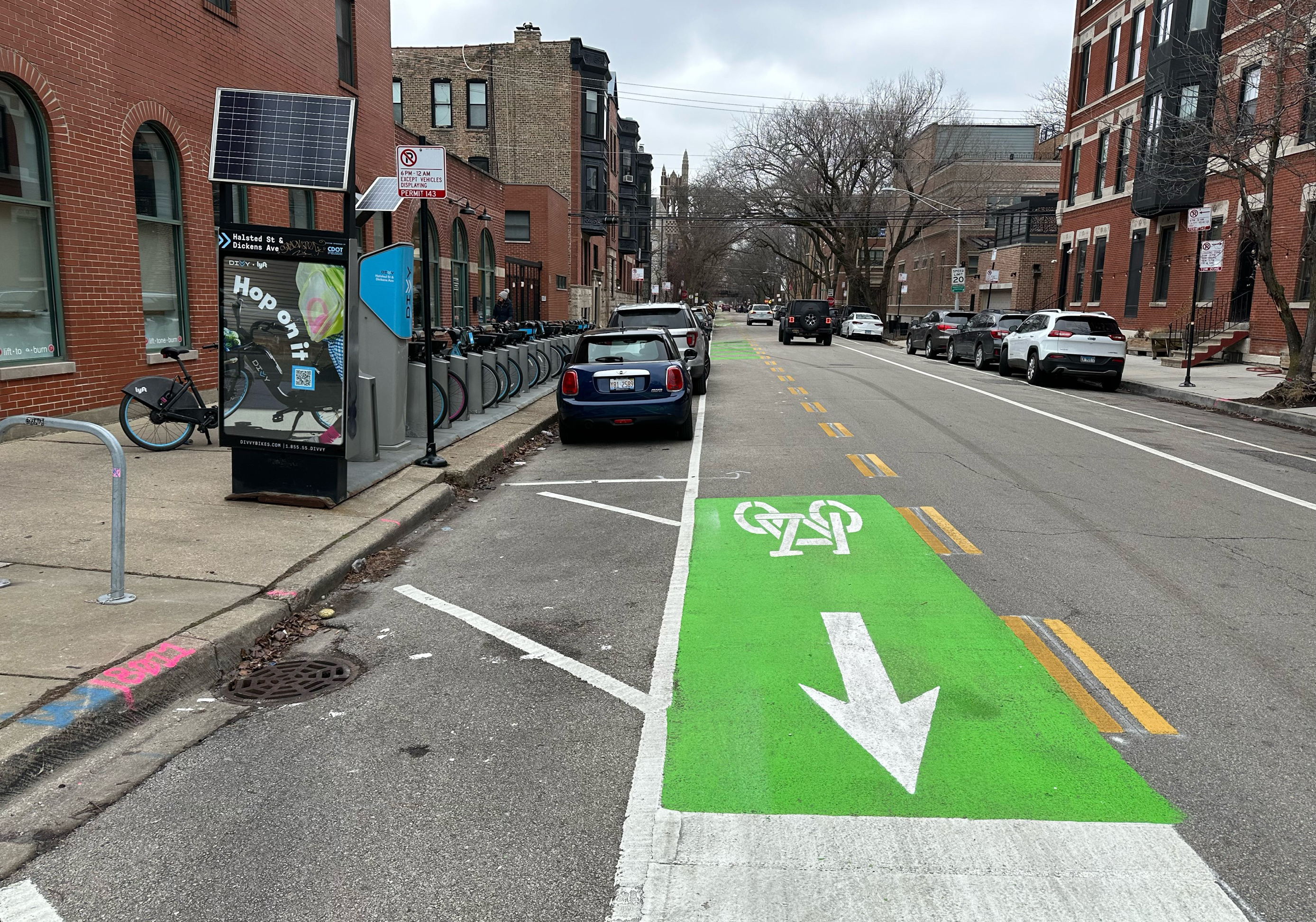 View of roadway with person biking and divvy bike share station